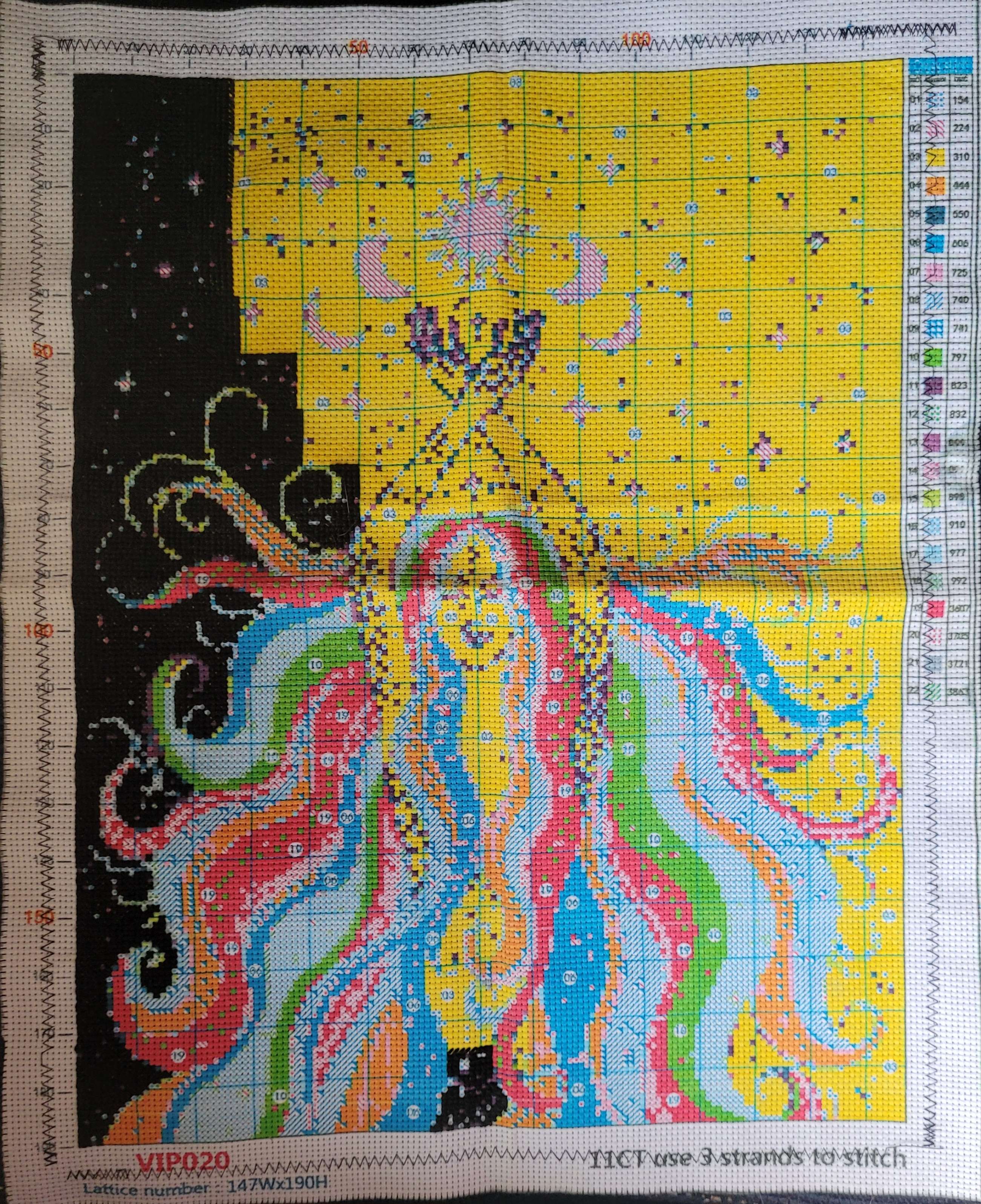 A stamped cross stitch kit of a woman with rainbow hair, it is not completed