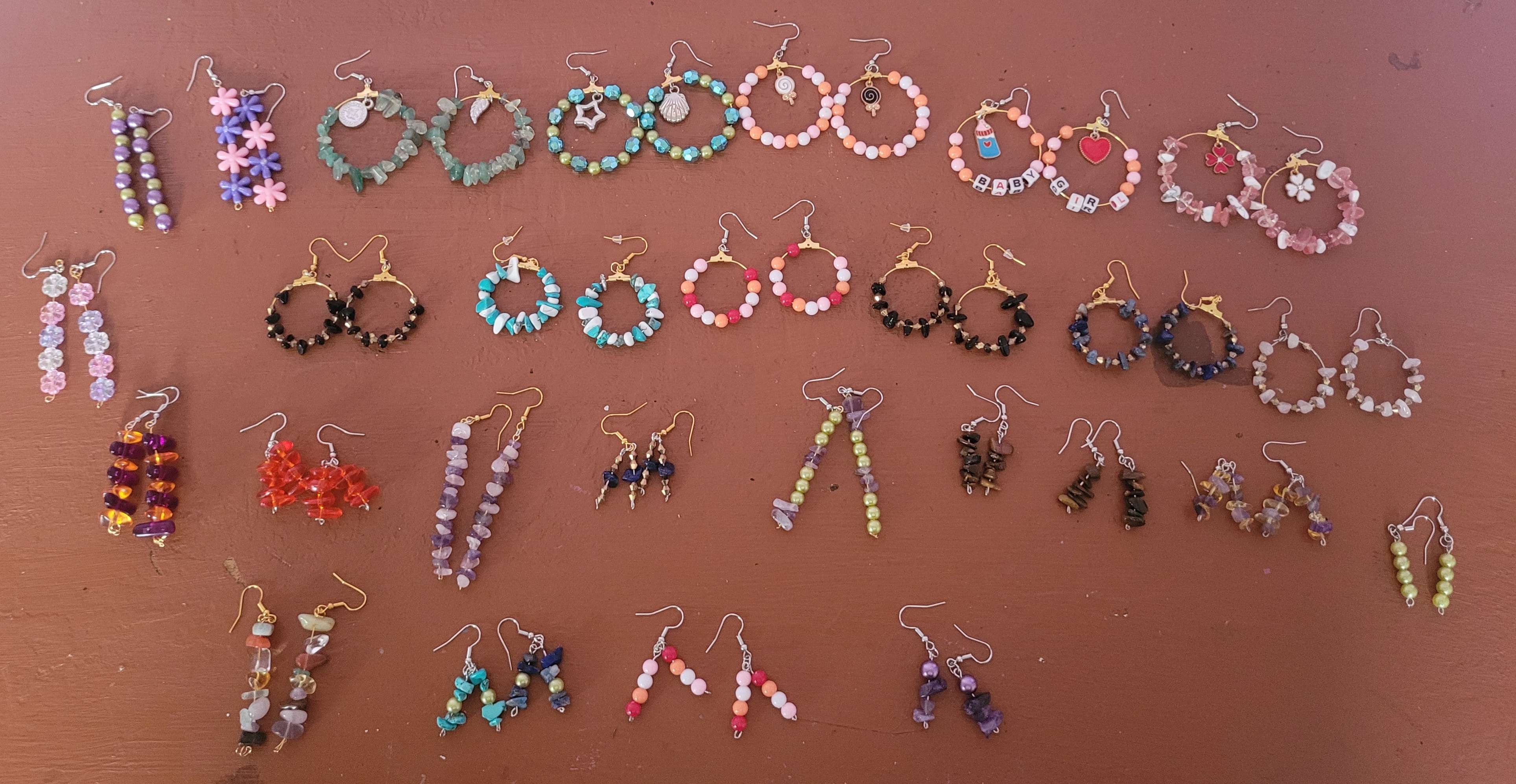 Various handmade earrings on a table.